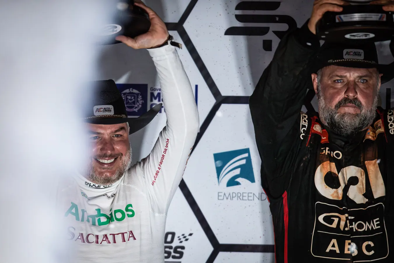 Rafael ergue o troféu no pódio ao lado de outro piloto